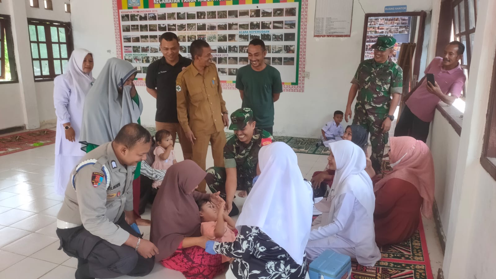 PERSONEL POLSEK PANGA –  DAMPINGI TIM UPTD GELAR KEGIATAN TETES POLIO