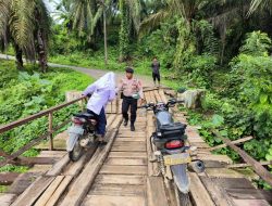 EFEK JEMBATAN RUSAK –  ANGGOTA POLSEK BANDA ALAM TURUN MEMBANTU WARGA