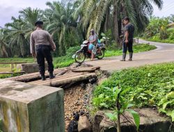 EFEK JEMBATAN RUSAK –  PERSONEL POLSEK BANDA ALAM TURUN MEMBANTU WARGA