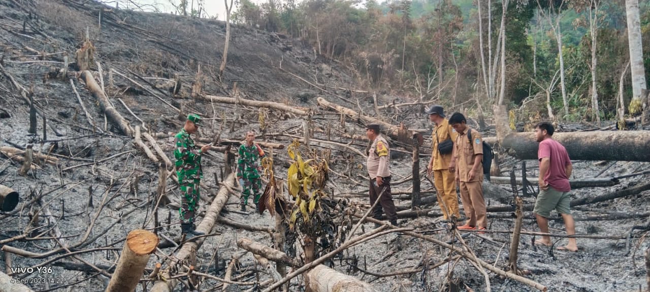 Personil Polsek Muara Siau Pasang Garis Polisi pada Lahan Yang terbakar