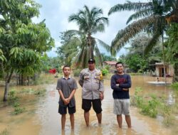 Bhabinkamtibmas Polsek Mandiangin, Bripka Sutomo, melakukan pengecekan debit air di Desa Kertopati menyusul tingginya curah hujan belakangan ini.