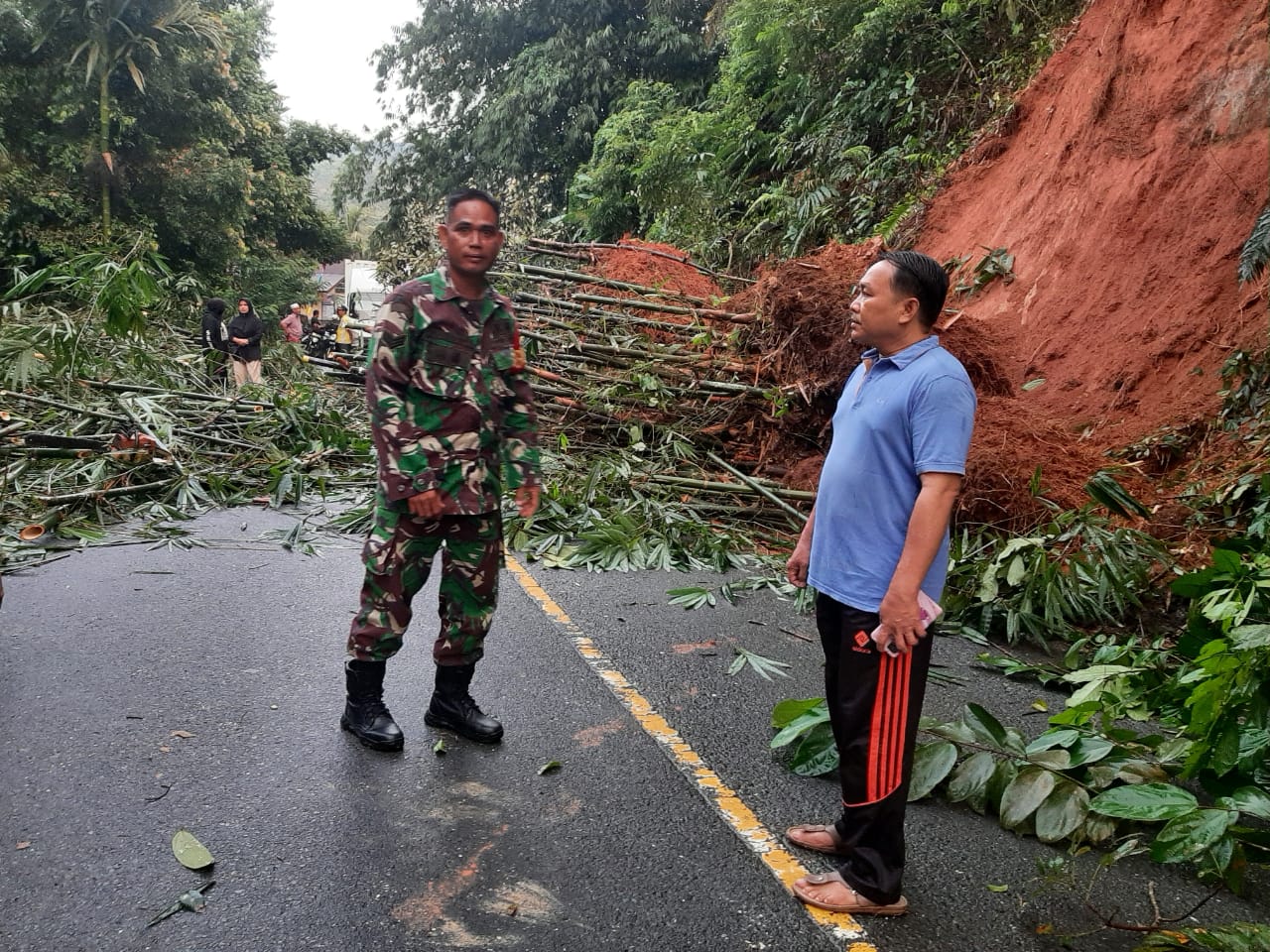 Anggota Koramil Sungai Manau Kodim 0420/Sarko Bersama Personil Polsek Sungai Manau dan Masyarakat Bersihkan Material Longsor