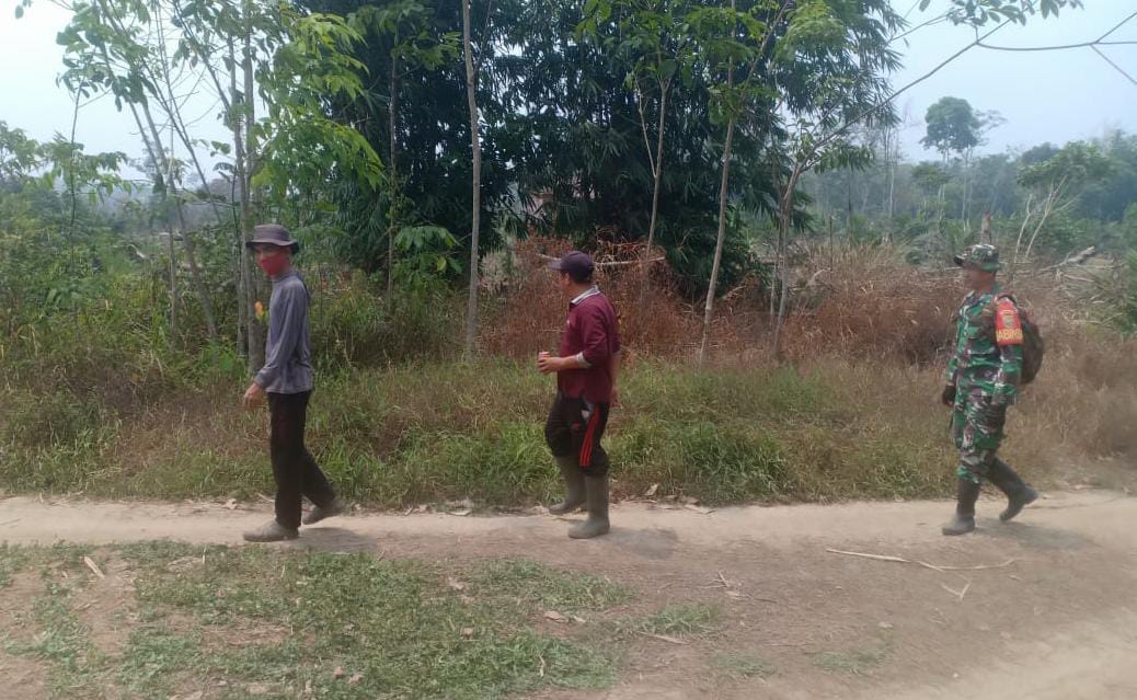 Berjalan Kaki, Babinsa Serda Ansori Ajak Warga Cek Lahan Rawan Kebakaran 