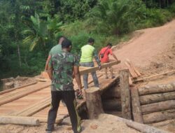 Anggota Satgas TMMD 122 Kodim 0420/Sarko terus melanjutkan pekerjaan jembatan darurat di Desa Bedeng Rejo menuju desa Sungai Putih