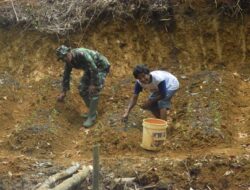 Dibantu Warga, Anggota Satgas TMMD Menabur Pupuk Pada Tanaman Cabai