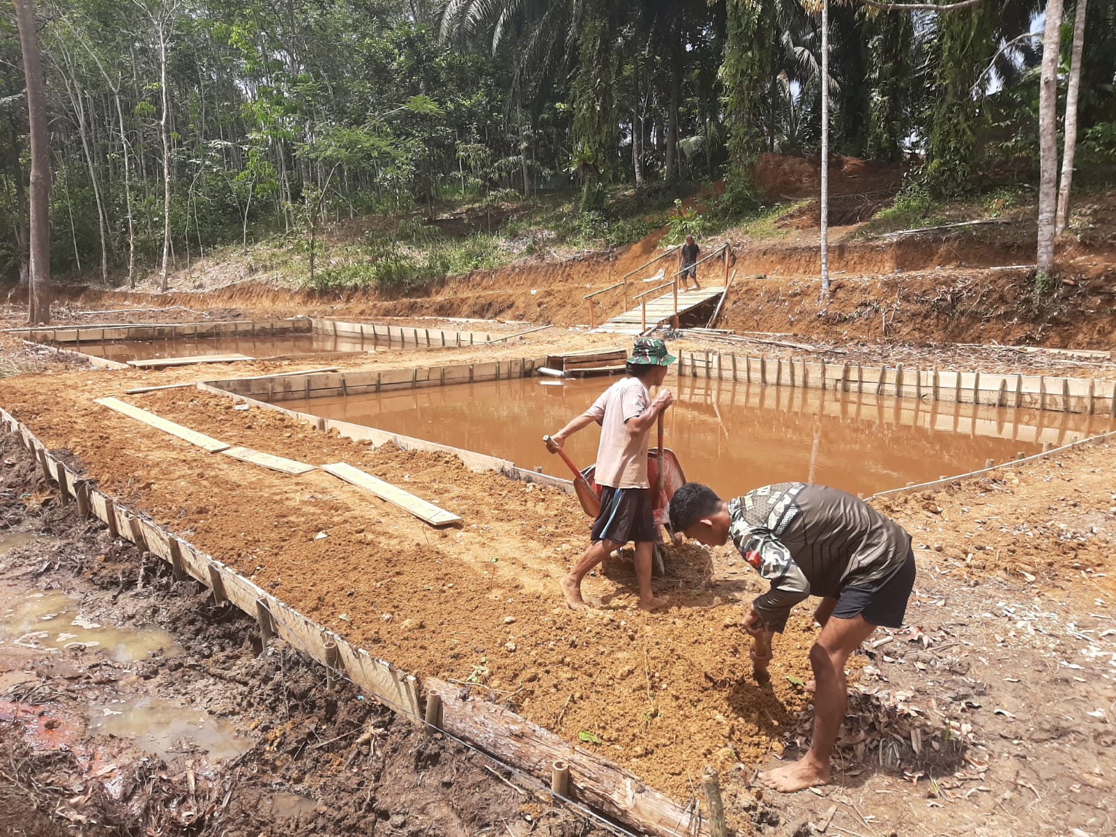 Anggota Satgas TMMD dan Warga Perkeras Bantaran Kolam Ikan