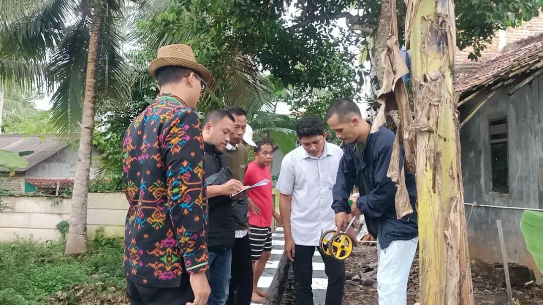 KEPALA DESA SINDANG HEULA TINJAU LANGSUNG KEGIATAN OPNAME PEMBANGUNAN SPAL DAN DRAINASEI