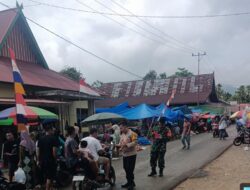 Babinsa dan Bhabinkamtibmas Bagikan Bendera Merah Putih di Desa Pasar Muara Siau