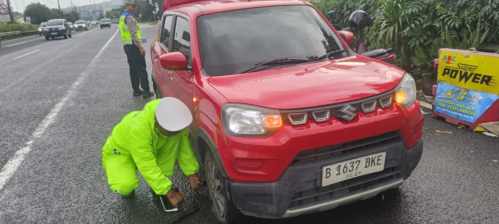 Personel Satlantas Polresta Bandara Soetta membantu Pengemudi grab yang Pecah Ban dan mengantarkan Penumpangnya menghindari keterlambatan ke Terminal 2 Bandara Soetta.